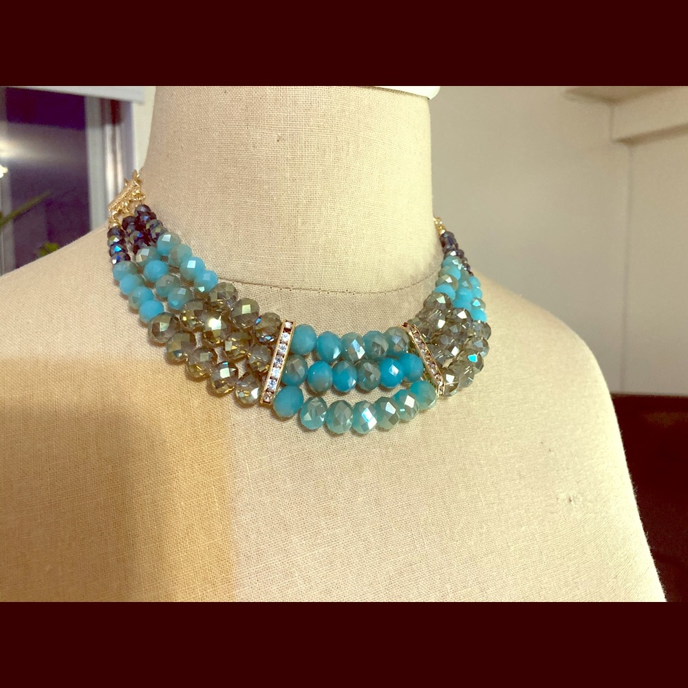 Detailed necklace with turquoise and grey beads.